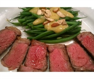 Here are four ounces of steak on a large dinner plate. Behind them are 12 ounces of green beans, with a mustard sauce.
